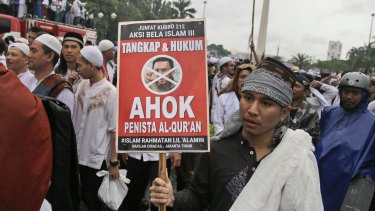 A man holds a poster during a rally against Jakarta's then governor Basuki "Ahok" Tjahaja Purnama, a Christian accused of blaspheming against Islam.