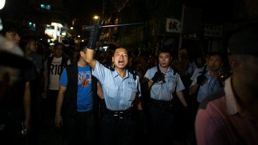 Identifiable: A policeman addresses the crowd during demonstrations in the Mong Kok area.