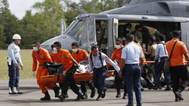 Indonesian search and rescue unload the body of an AirAsia passenger at Pangkalanbun on the island of Borneo. 