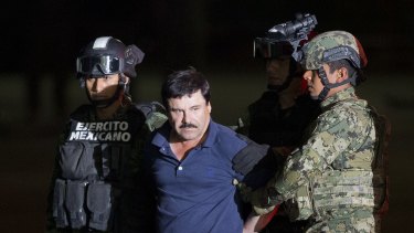 Joaquin "El Chapo" Guzman is made to face the press as he is escorted to a helicopter in handcuffs by Mexican soldiers and marines last week. 