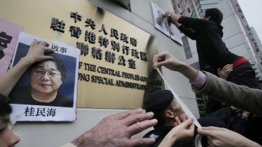 Protesters with photos of missing booksellers during a protest outside the Liaison of the Central People's Government in Hong Kong on Sunday. 