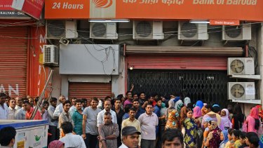 Rupee withdrawal: customers wait in line to exchange discontinued rupee banknotes at a Bank of Baroda branch in Dadri, Uttar Pradesh, India.