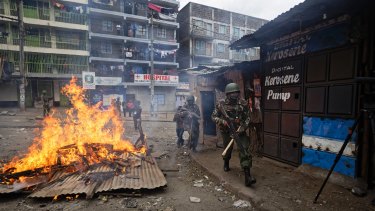 Riot police advance towards protesters during clashes in the Mathare area of Nairob.