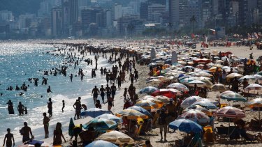 People gather on Ipanema beach, a landmark tourist destination in Rio. 