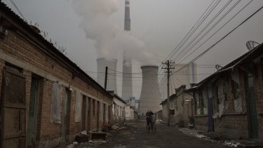Riding a bike near a coal fired power plant on the outskirts of Beijing earlier this week. 