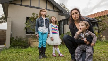 Dana Nehal Joab in front of her house - which she may lose - with her children Hannah, 9, Jennah, 5, and Noah, 17 months.