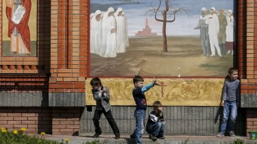 Children play in front of a church at the memorial for victims of the Chernobyl nuclear disaster in Kiev on Sunday.