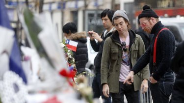 Members of the band Eagles of Death Metal, Jesse Hughes, right, and Julian Dorio, pay their respects to 89 victims who died in the Novermber 13 attack at the Bataclan concert hall in Paris last year. 