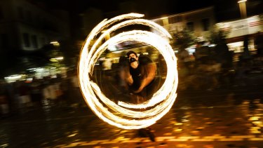 Juggling fire to earn money in Athens: Few jobs are available for students living away from home.