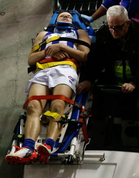 Kayne Turner of the Kangaroos is stretchered from the field.