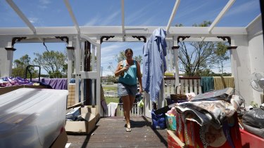 Yeppoon resident Demelza Bischoff walks onto the roofless veranda of her home on Saturday, after it was damaged during Cyclone Marcia.