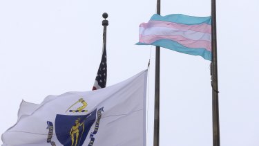 A flag representing the transgender community, right, flies next to the Massachusetts state flag and an American flag in front of Boston City Hall on Monday. 