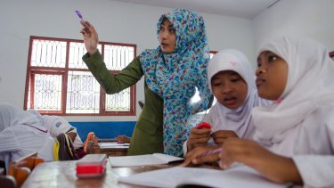 Class action: A teacher and pupils at a school run by anti-trafficking NGO Yayasan Kusuma. 