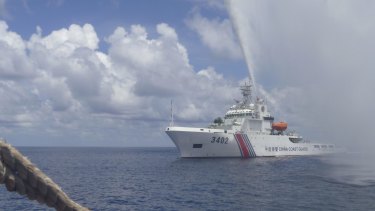 Tensions: A Chinese Coast Guard vessel sprays a water cannon at Filipino fishermen near Scarborough Shoal last year. 