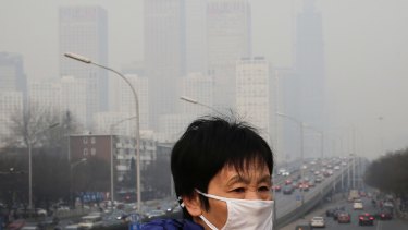 A woman wears a mask for protection against pollution as Beijing is shrouded in smog. 