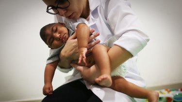 Dr Stella Guerra performs physical therapy on an infant born with microcephaly in Recife, Brazil, caused by the zika virus in pregnancy.