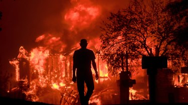 Jim Stites watches part of his neighborhood burn in Fountaingrove, Califonia, on Monday.