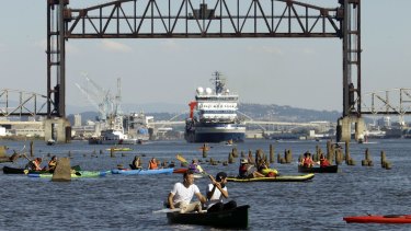 Kayakers gather as the Royal Dutch Shell PLC icebreaker Fennica heads under a railroad bridge and up the Willamette River in Portland on Thursday. 