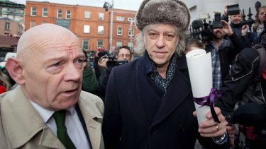Irish rock singer Bob Geldof, right, holding his Freedom of the City of Dublin scroll with Councillor Mannix Flynn arrives at City Hall on Monday to hand it back