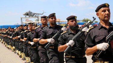 Palestinian Hamas security forces march past the wreckage of late Palestinian Authority president Yasser Arafat's helicopter, at a police academy graduation in Gaza City. 