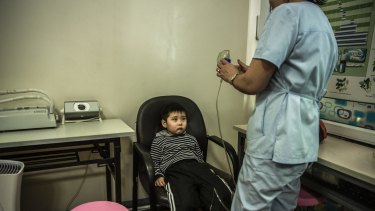 Temuulen Ganzorig, five, prepares to inhale medication through a nebuliser as part of his treatment for the flu at the Batchingun clinic in Ulaanbaatar.