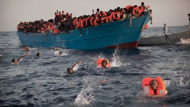 Migrants, mostly from Eritrea, jump into the water as they are rescued in the Mediterranean sea, off Sabratha, Libya, on Monday.