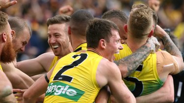Dylan Grimes (No.2) embraces his teammates after the siren in the 2017 AFL grand final.