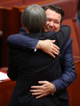 Liberal senator Dean Smith hugs senator Penny Wong after introducing the bill.