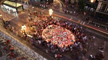 People pay respect at a memorial tribute of flowers, messages and candles to the victims on Barcelona's historic Las Ramblas.