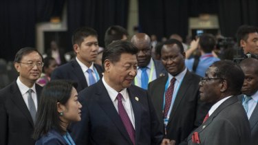 Chinese President Xi Jinping talks with Zimbabwean President Robert Mugabe in Johannesburg, South Africa, on December 5.
