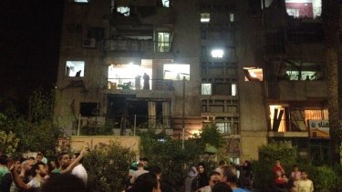 People look into and out of a building damaged by a bomb that exploded early on Thursday in Cairo.