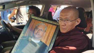 A Buddhist monk holds a portrait of Ko Ni, who spoke out about how the constitution stacked power in the hands of the military and was inconsistent with democracy.  