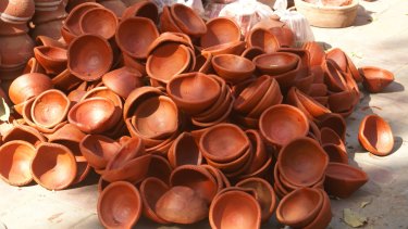 Plain clay diyas are piled high for sale as families prepare to light up their homes.