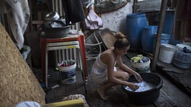 Marilia da Silva, 14, washes her clothes in a slum in Recife, Brazil. The Zika virus, spread by the Aedes aegypti mosquito which also spreads dengue, thrives in people's homes and can breed in even a bottle cap's-worth of stagnant water.