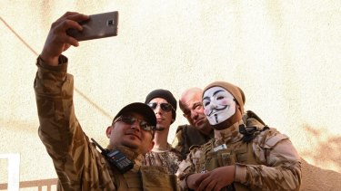 Westerners who have joined the Iraqi Christian militia Dwekh Nawsha to fight against Islamic State militants, take a photograph together in Dohuk.