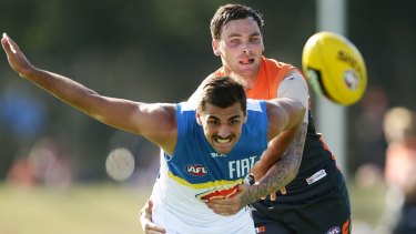 The Suns' Andrew Boston is challenged by GWS player Nathan Wilson during a NAB Challenge match earlier this year. 