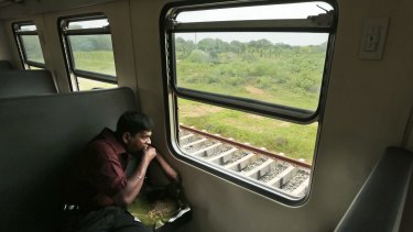 An ethnic Sinhalese Sri Lankan man eats his lunch during a train ride. For the hundreds of thousands of minority ethnic Tamils, the Sri Lankan government's repeated promises of post-war reconciliation ring false.
