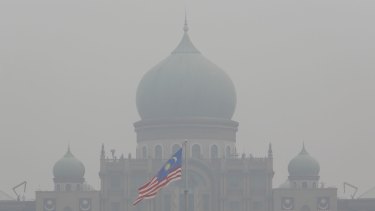 A Malaysian flag flutters in front of the prime minister's office shrouded in haze in Putrajaya, Malaysia, at the weekend.