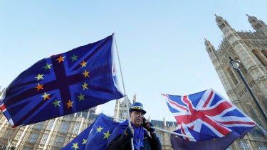 An anti Brexit demonstrator waves EU and British flags in Westminster in London on Friday.