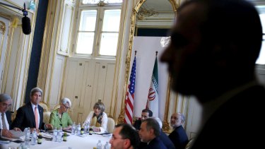 An Iranian security guard stands as US Secretary of State John Kerry (second from right) meets with the Iranian delegation including Iranian Foreign Minister Mohammad Javad Zarif in Vienna.