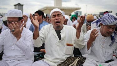 A Muslim man weeps as he prays during the rally on Friday. 