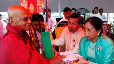 General Min Aung Hlaing and his wife Daw Kyu Kyu Hla offer alms to Buddhist monks earlier this month.