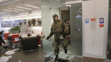 Right-wing paramilitary veterans in Ukraine attacked two offices of Russian banks in the capital amid observances of the second anniversary of the protests that brought down the Russia-friendly president. 