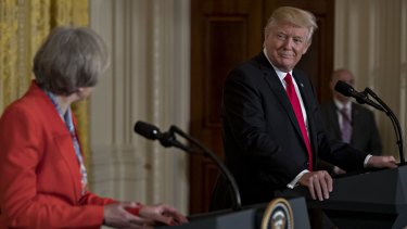 US President Donald Trump, right, listens as Theresa May, UK prime minister, speaks.