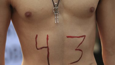 A protester with the number 43 painted on his body marches in Mexico City.