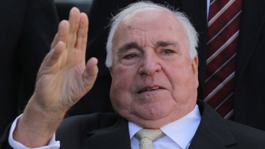 Former German Chancellor Helmut Kohl waves at supporters from his wheelchair in 2010.