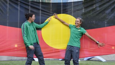 Proud players: Lydia Williams and Kyah Simon with their giant Aboriginal flag in Canada.