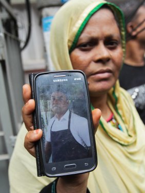 Johura Begum shows a photograph of her brother-in-law Saidul Islam, who works at the Holey Artisan Bakery and is currently missing.