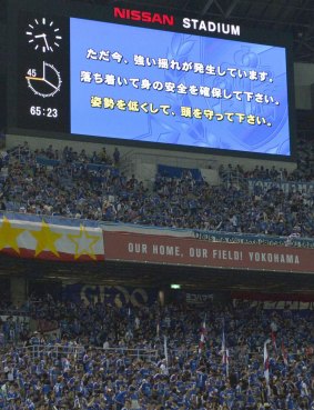 A large screen displays an earthquake alert to soccer fans as a strong earthquake jolts Shonan BMW Stadium near Tokyo.