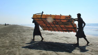 Rohingya fishermen carry a fishing raft made of plastic containers, after their sturdy fishing boats were outlawed.